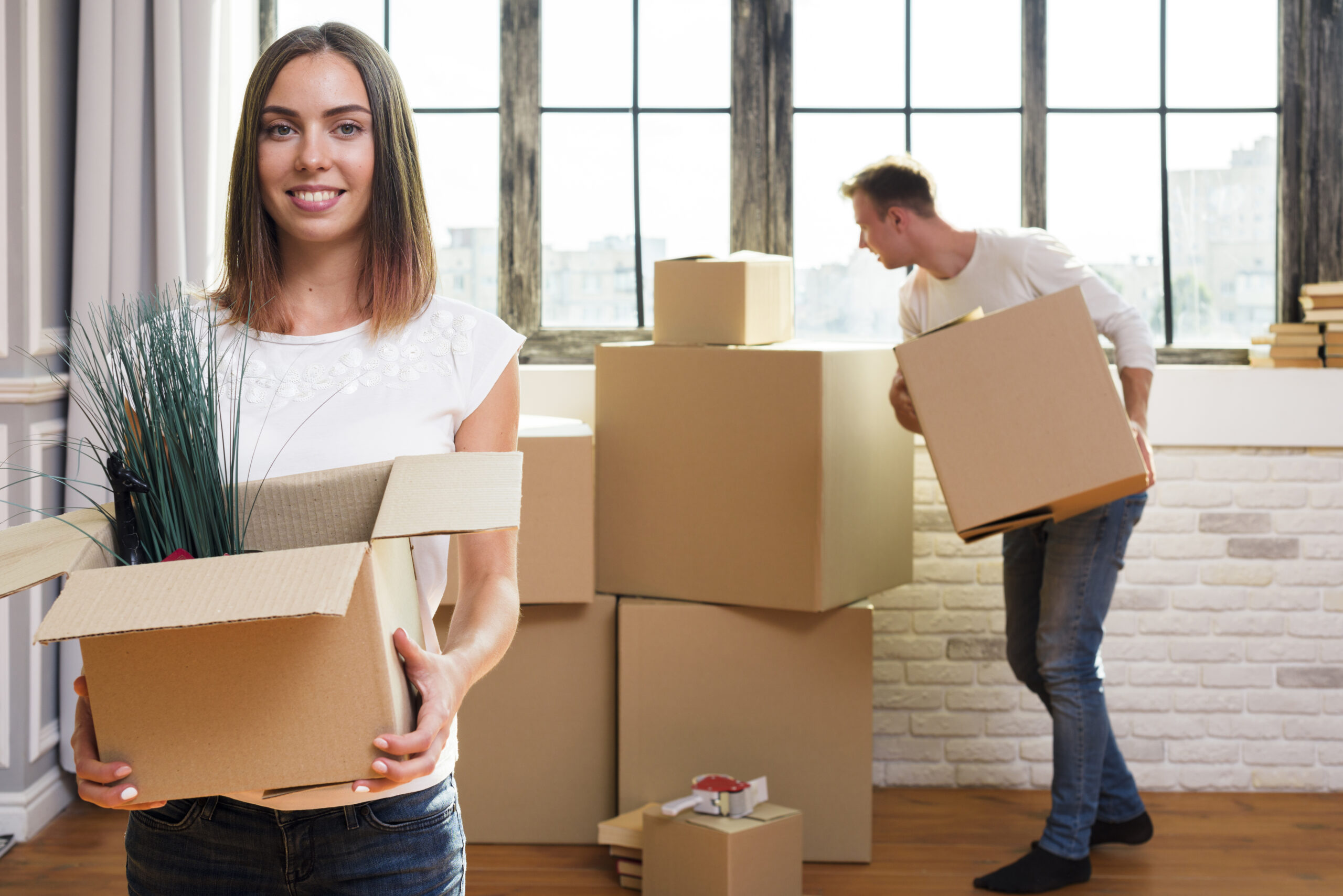 woman-holding-cardboard-box-with-plants